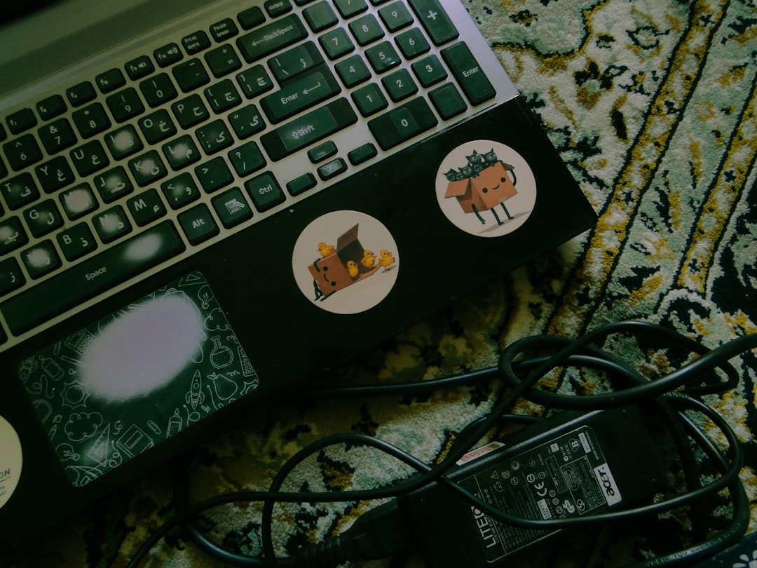 laptop-with-stickers-on-a-patterned-rug-pod0dp6tjbe