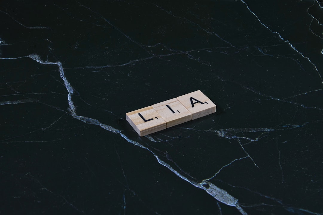wooden-tile-with-lia-letters-on-dark-marble-goxcpkl0vx0