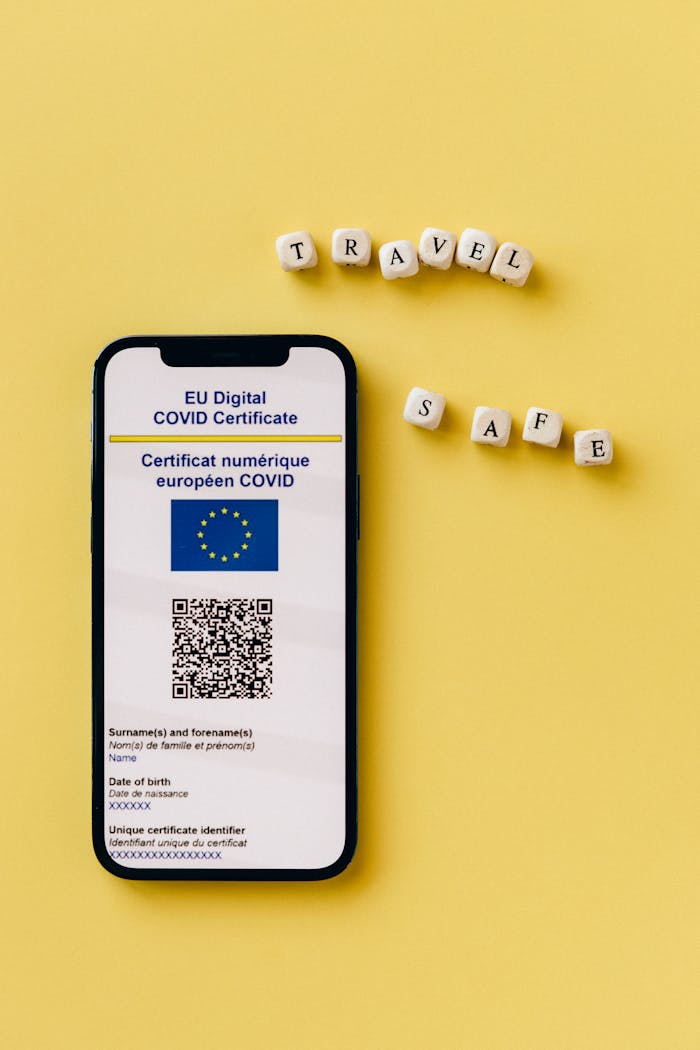 Smartphone showing EU Digital COVID Certificate with travel themed dice on yellow background.